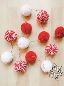 Guirnalda navideña de pompones rojos y blancos con hilo trenzado, acompañada de copo de nieve decorativo para Navidad