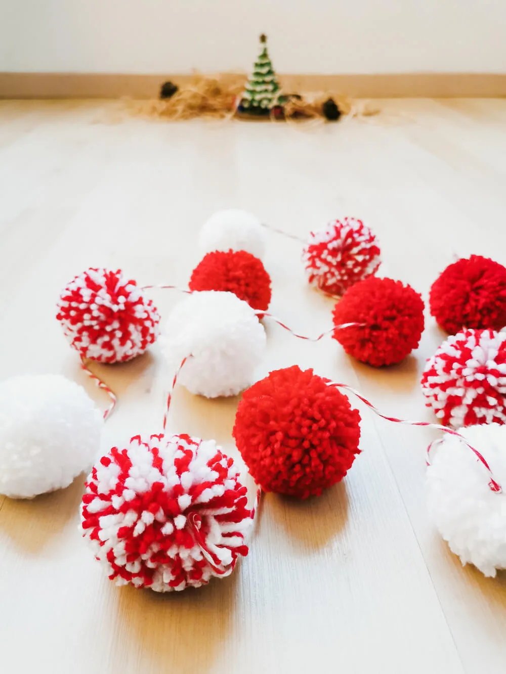 guirnalda-blanca-y-roja-para-navidad Guía de pompones rojos y blancos hecha a mano, perfecta como decoración de Navidad para añadir un toque cálido y original al hogar.