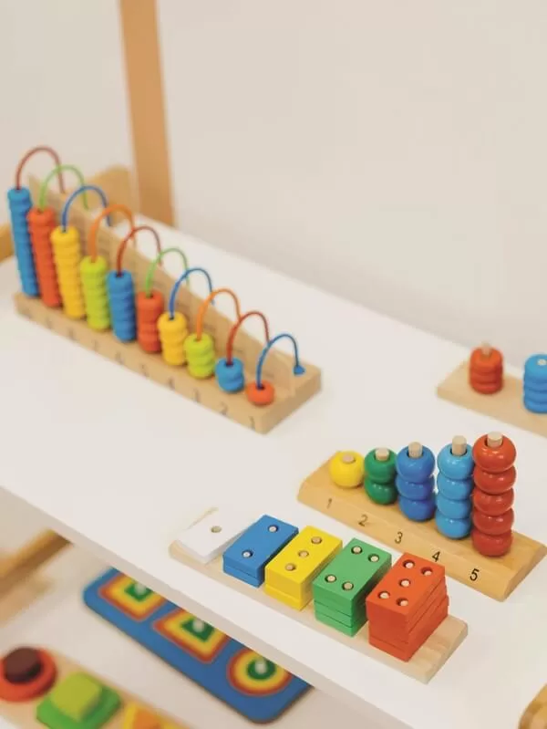 Mueble montessori para niños con materiales en colores vibrantes ordenados y al alcance de los niños, uno de los principales beneficios de un shelf montessori