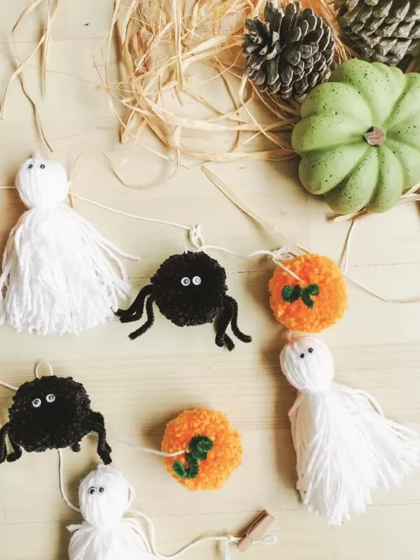 guirnalda-halloween-decoracion-otoñal Guirnalda artesanal con elementos de Halloween como arañas negras y fantasmas blancos, pensada para una decoración de Halloween natural y sencilla.