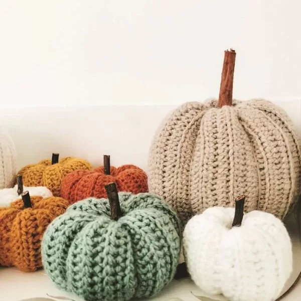 Conjunto de calabazas decorativas tejidas en tonos otoñales, ideales para una decoración cálida y artesanal.