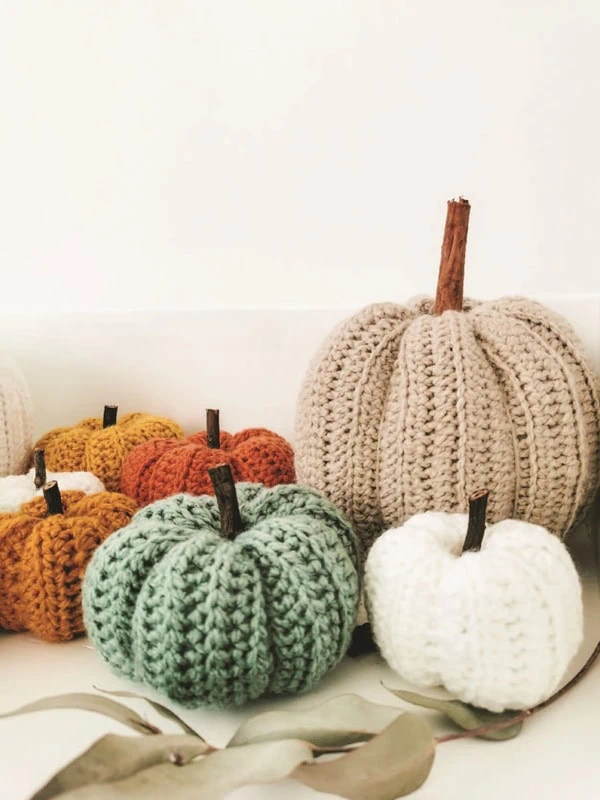Conjunto de calabazas decorativas tejidas en tonos otoñales, ideales para una decoración cálida y artesanal.