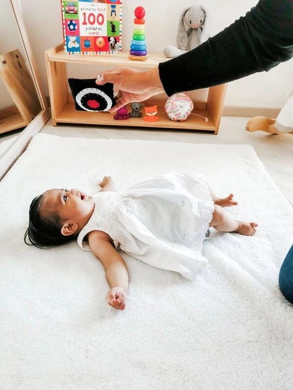 Bebé observando una tarjeta de alto contraste en blanco y negro como parte de la estimulación visual temprana